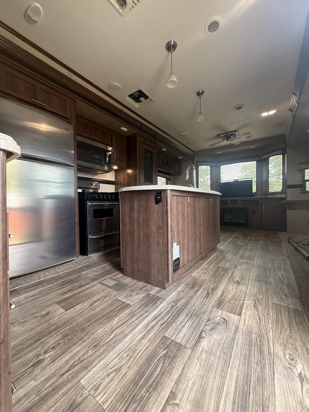 Kitchen with stainless fridge, gas range and island
